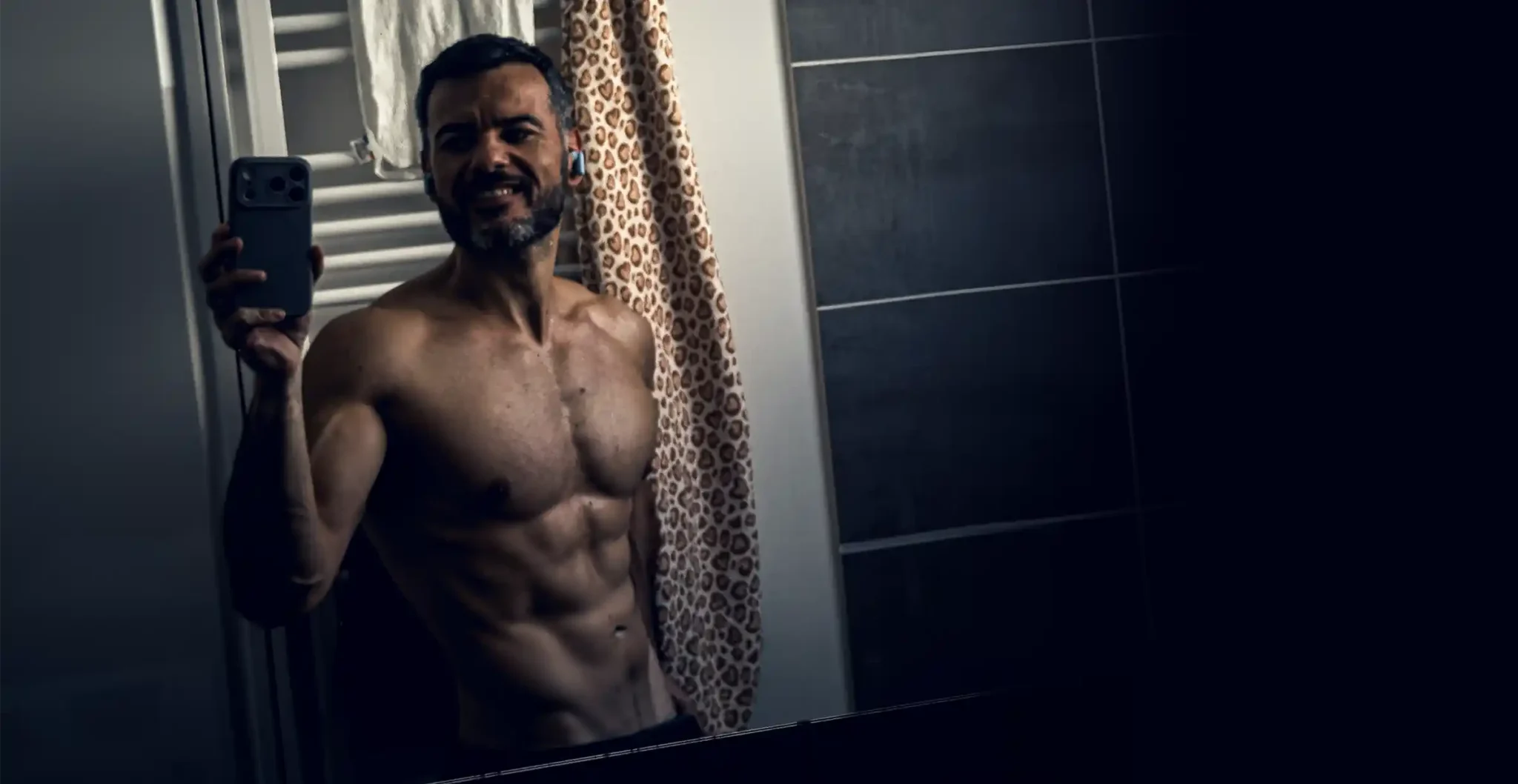 Homme musclé avec abdos visibles devant un miroir