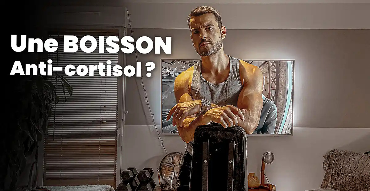 Homme musclé en débardeur posant dans son salon de musculation avec le texte « Une boisson anti-cortisol ? », illustration du lien entre cortisol et glucides pendant l’entraînement