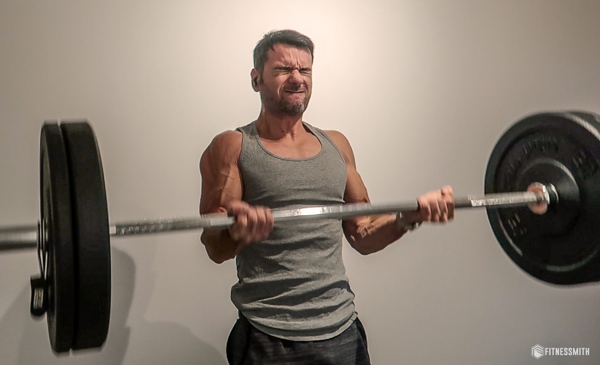 Un athlète soulevant des poids lourds pour préserver ses muscles pendant une sèche en musculation.