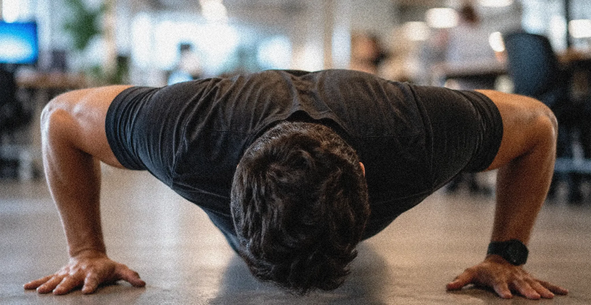 Adulte au bureau effectuant des pompes pour pratiquer l'exercice snacking.