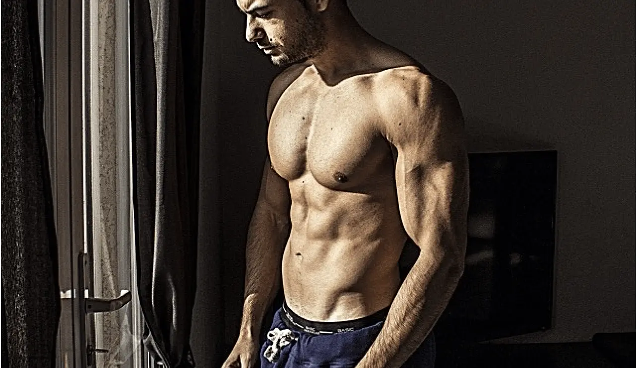 Homme adulte sec et musclé montrant un bas des abdominaux dessiné après perte de graisse abdominale